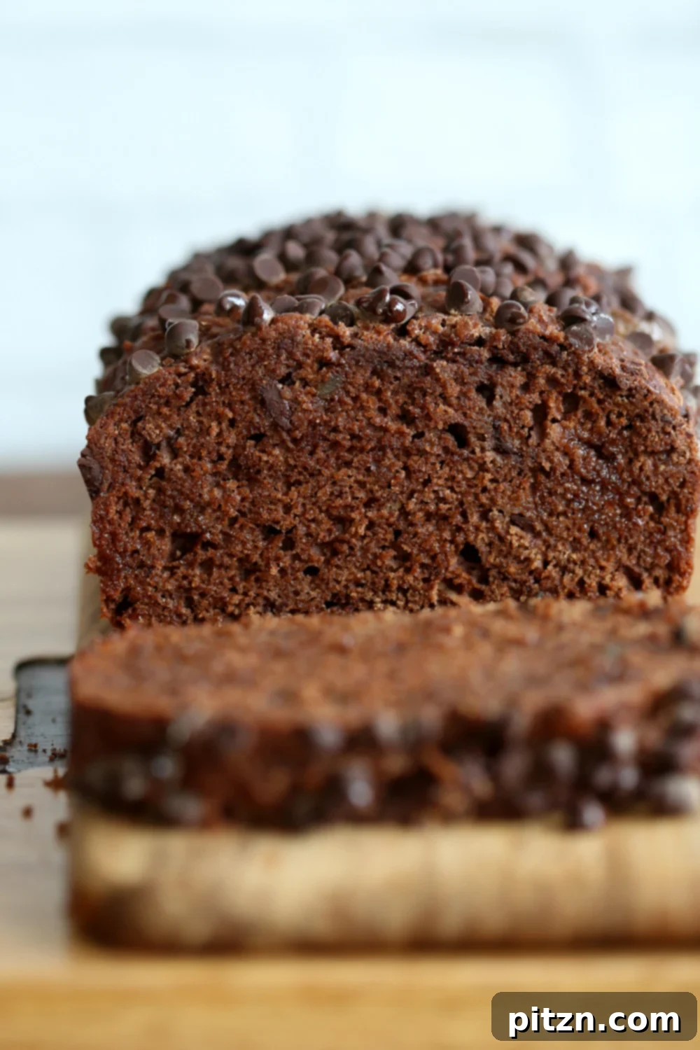 Spiced Vegan Chocolate Gingerbread Delight 4 Close-up of a slice of Vegan Chocolate Gingerbread Cake with visible candied ginger pieces and rich dark chocolate chunks.