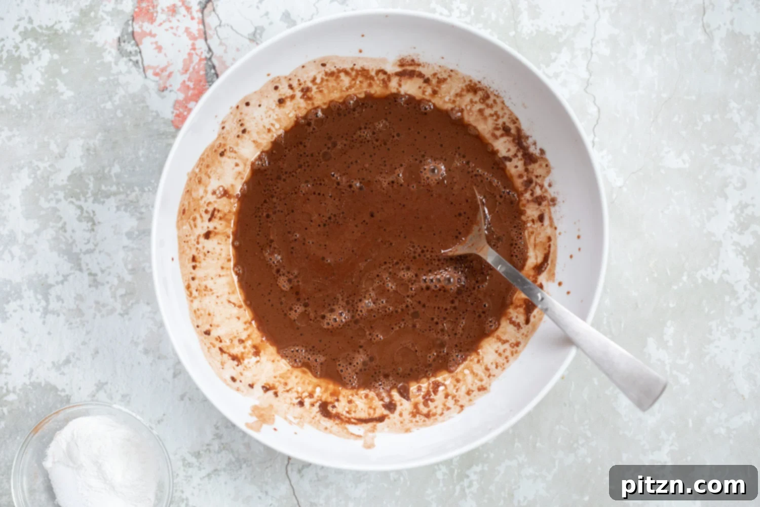 Spiced Vegan Chocolate Gingerbread Delight 6 Mixing process for Vegan Chocolate Gingerbread Cake batter in a white bowl.