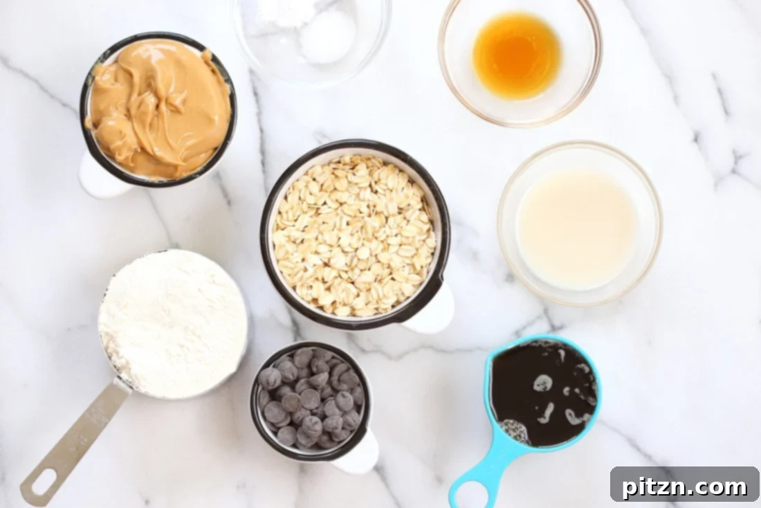 Easy One-Bowl Vegan Peanut Butter Oatmeal Chocolate Chip Cookies 4 All the necessary ingredients laid out on a table for Vegan Peanut Butter Oatmeal Chocolate Chip Cookies, including peanut butter, oats, chocolate chips, and other baking essentials.
