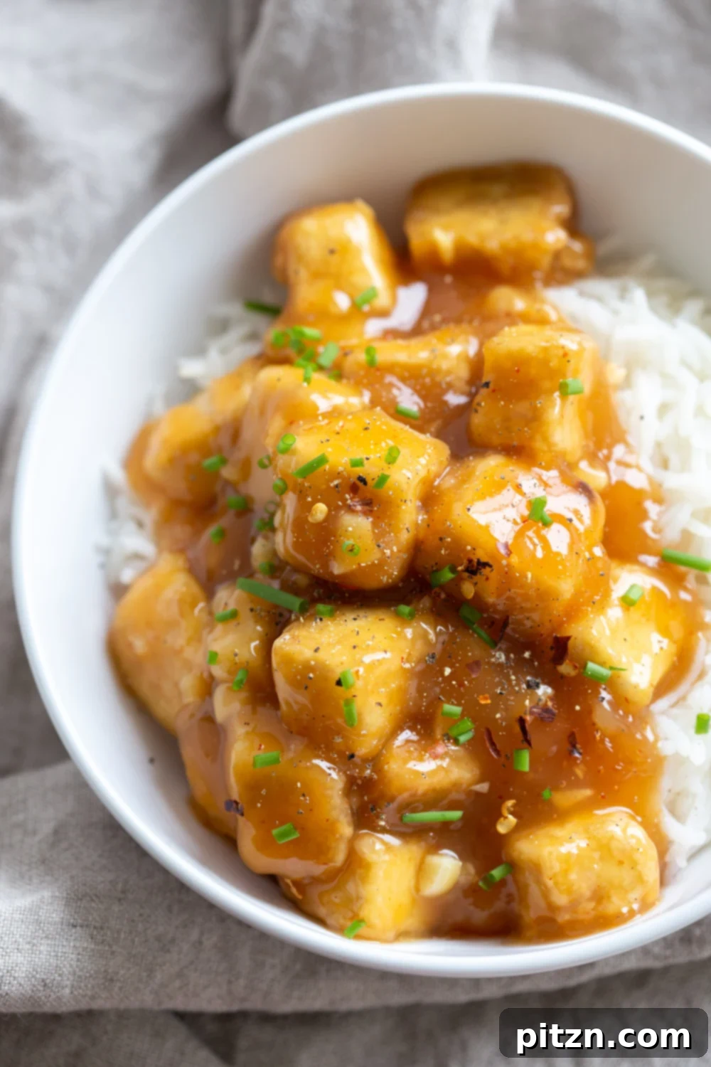 Zesty Vegan Orange Tofu 3 Easy Orange Tofu Recipe featuring baked crispy tofu with a delicious orange glaze. Perfect for a quick 30-minute weeknight meal, served with rice and blanched vegetables. Vegan, Gluten-free, Nut-free, with a soy-free alternative. #Vegan #Glutenfree #Nutfree #OrangeTofu #Recipe #VeganRicha