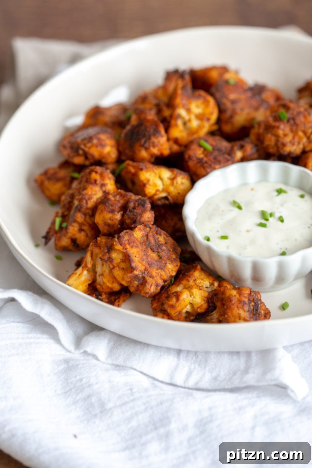 A close-up of Vegan Nashville Hot Cauliflower Bites, showcasing their appetizing texture and spicy coating. A delicious, plant-based, nut-free, soy-free, and gluten-free optional recipe.