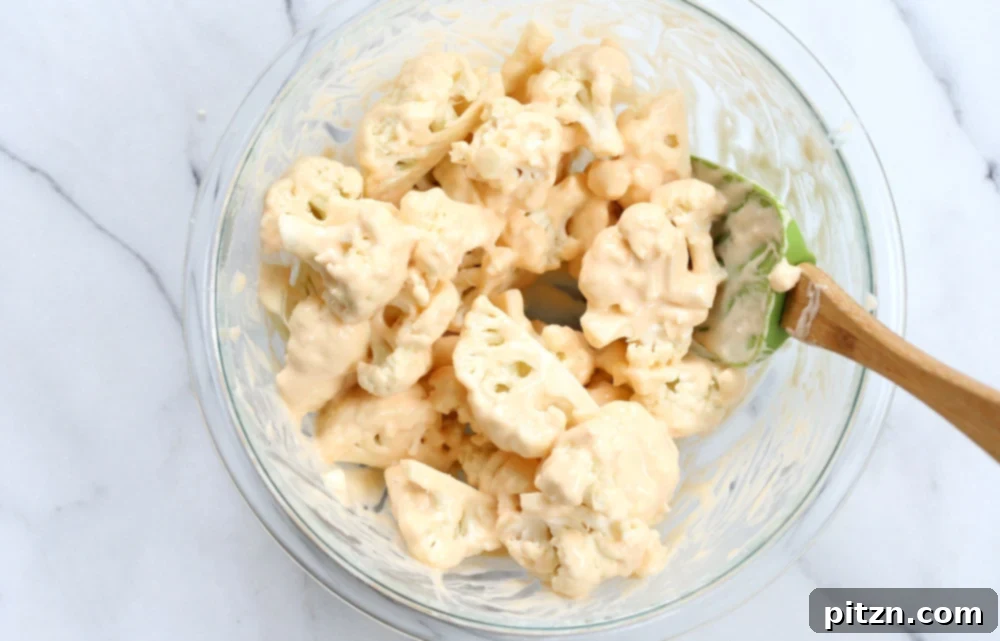 Cauliflower florets perfectly tossed in a thick, flavorful batter for our Vegan Nashville Hot Cauliflower Wings. Ready for their first bake to achieve ultimate crispiness.