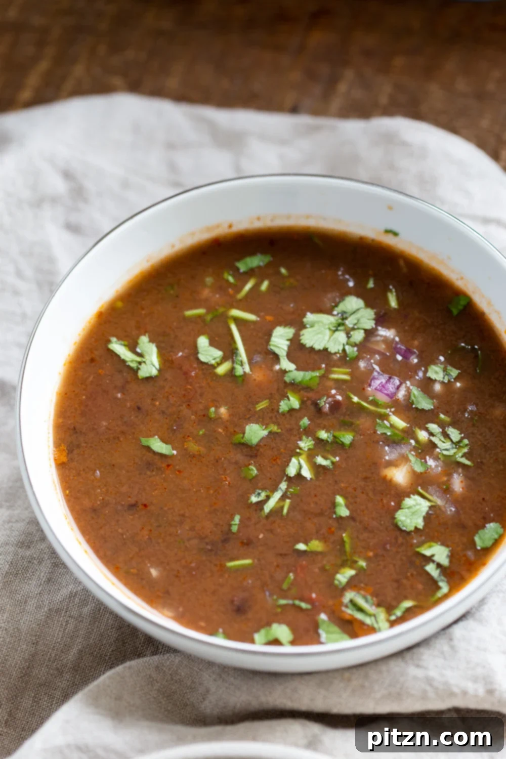 vegan black bean soup a bowl of vegan Instant Pot black bean soup sprinkled with chopped cilantro