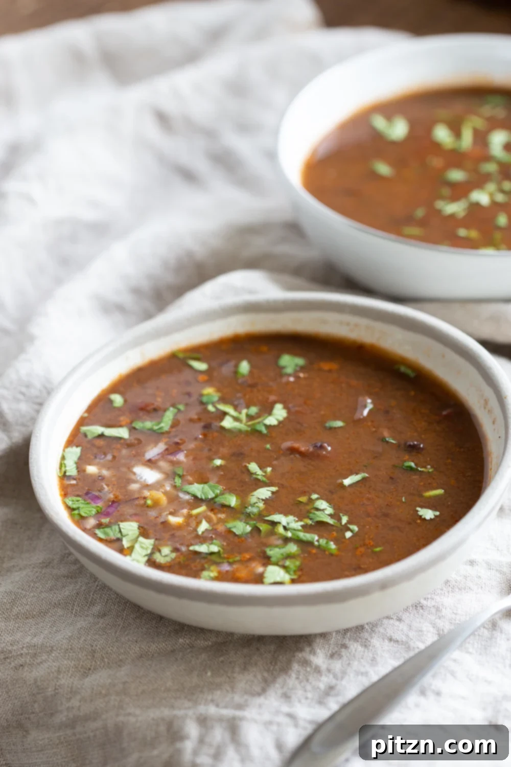 vegan black bean soup side view of a bowl of vegan Instant Pot black bean soup on a white cloth napkin