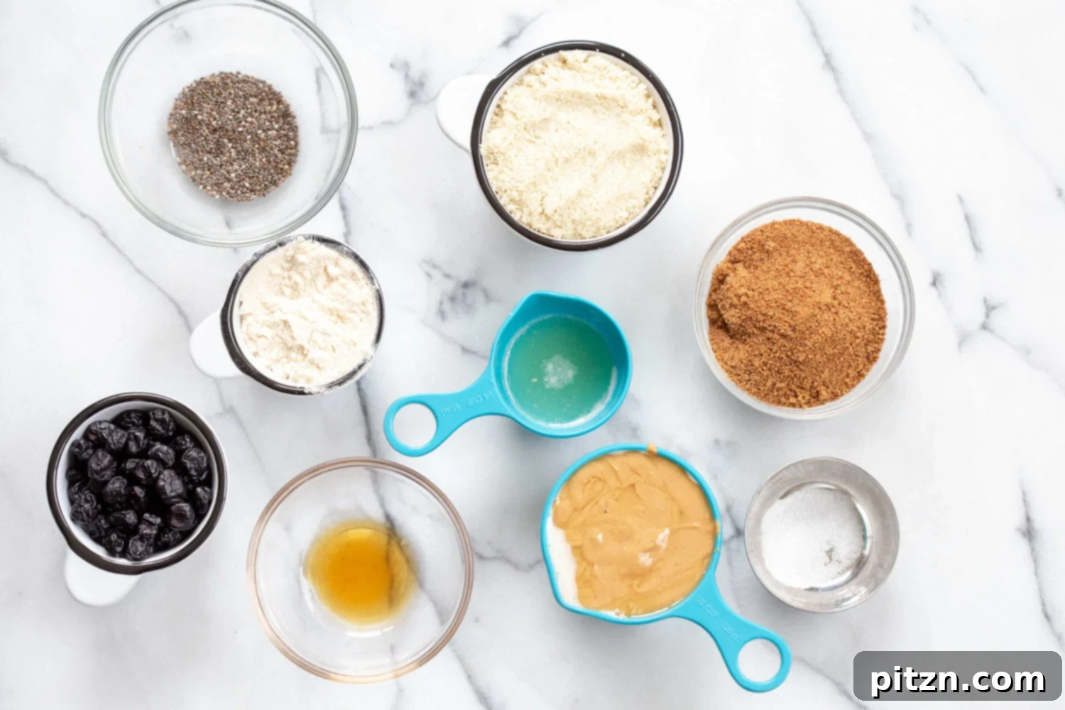 Ingredients for Vegan Blueberry Muffin Energy Bites displayed in individual bowls and measuring cups, ready for mixing.
