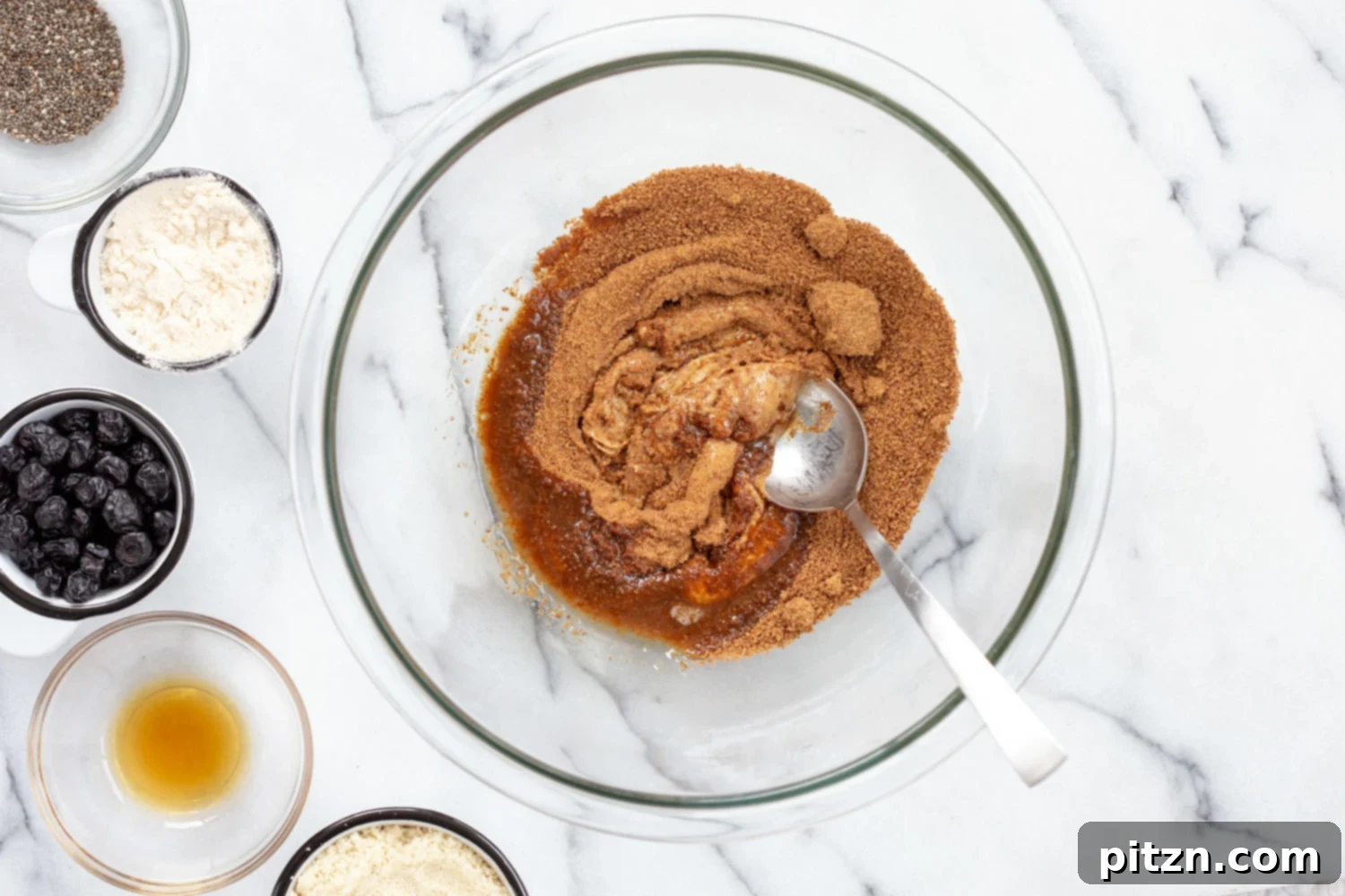 Smooth nut butter mixed with coconut sugar in a white bowl, forming the creamy base for the energy bites.