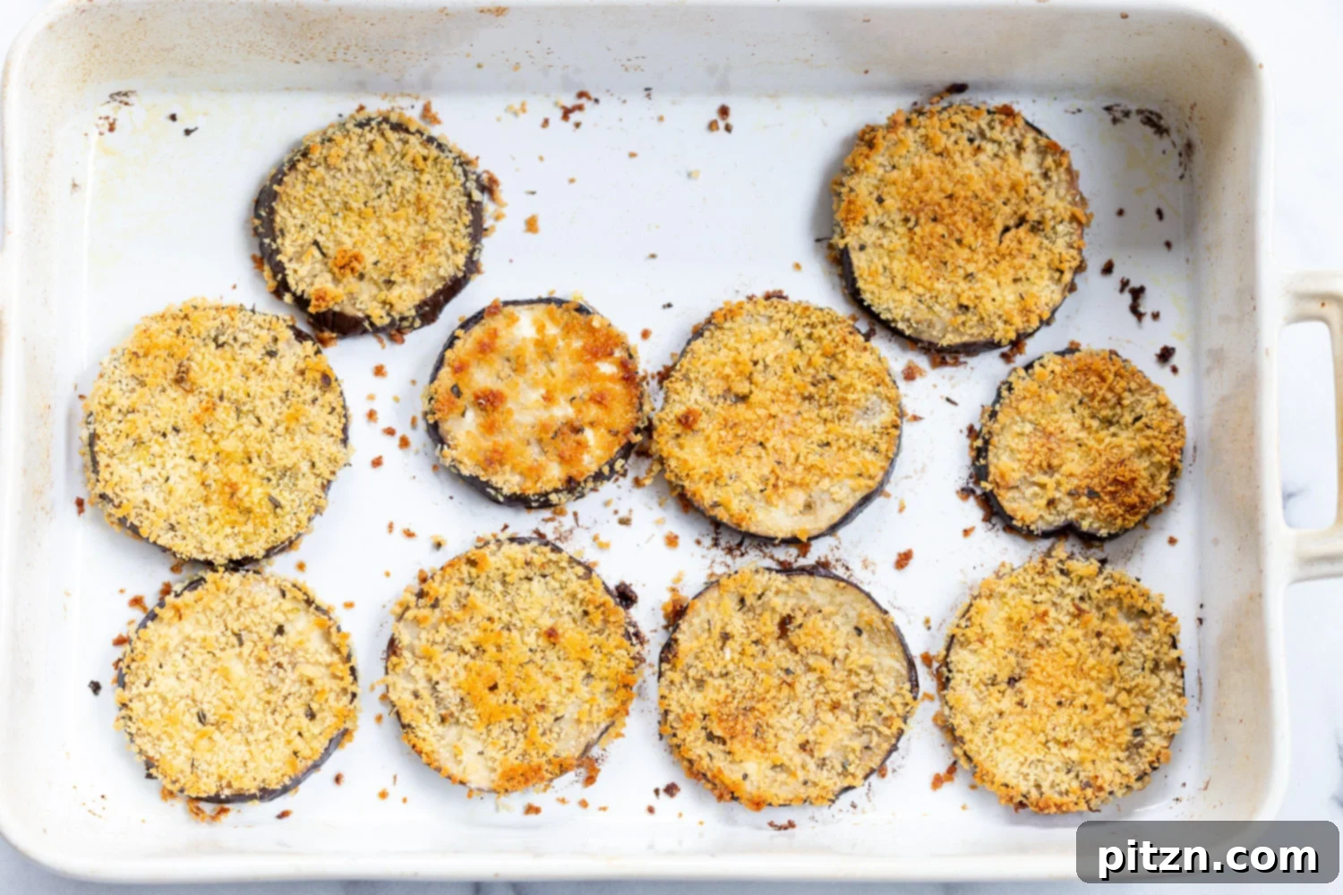 Simple Vegan Eggplant Parmesan 14 Baked breaded eggplant slices, golden and ready for assembly