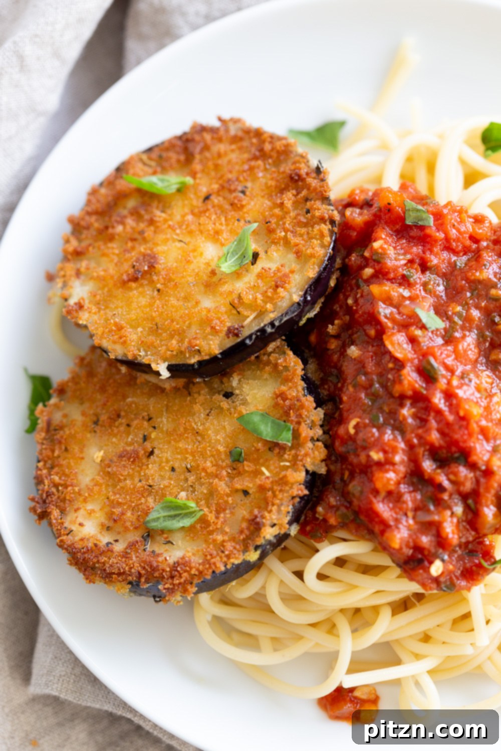 Simple Vegan Eggplant Parmesan 15 Vegan Eggplant Parmesan served with spaghetti and garnished with fresh basil