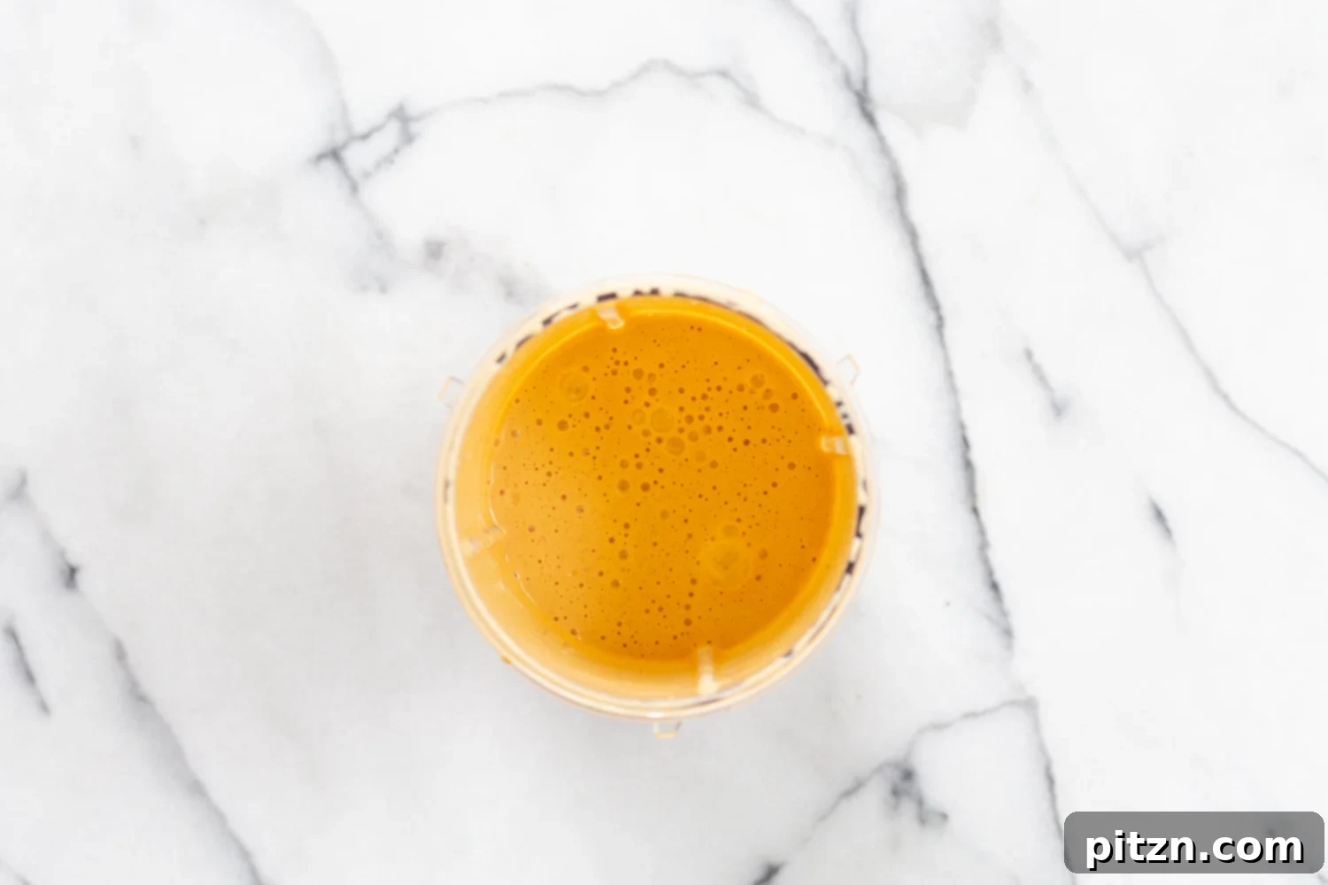 All the creamy Cajun pasta sauce ingredients being blended together in a high-speed blender, creating a smooth mixture.