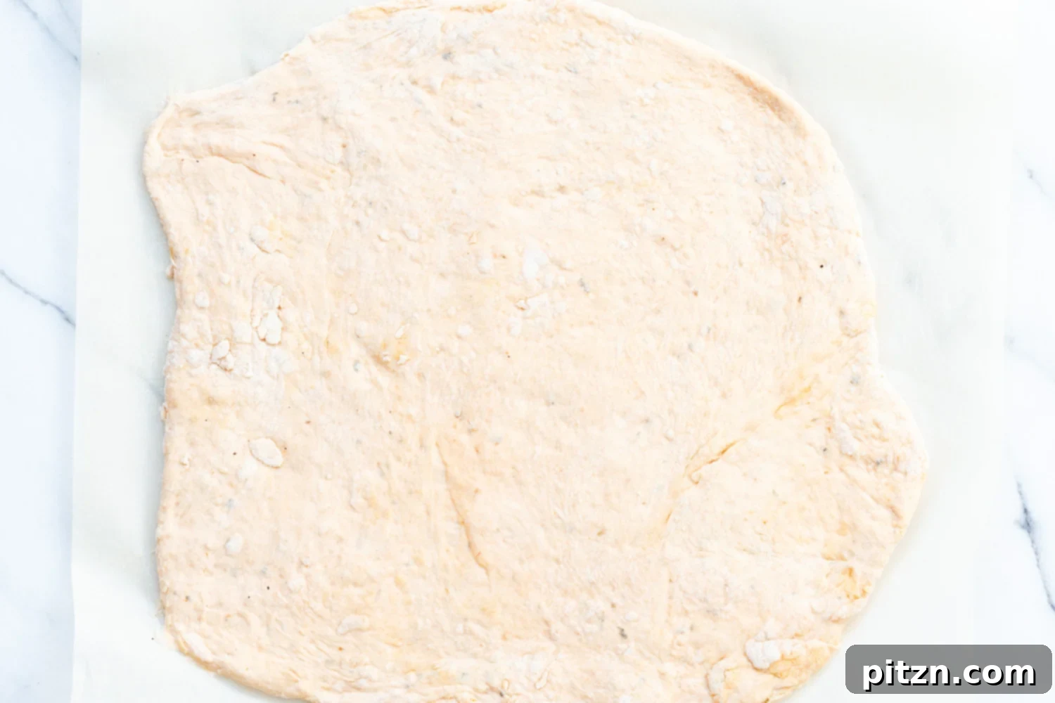 The Ultimate Vegan Pizza Rolls 10 Pizza dough for Vegan Pizza Rolls rolled out into a rectangle on parchment paper, ready for the filling.