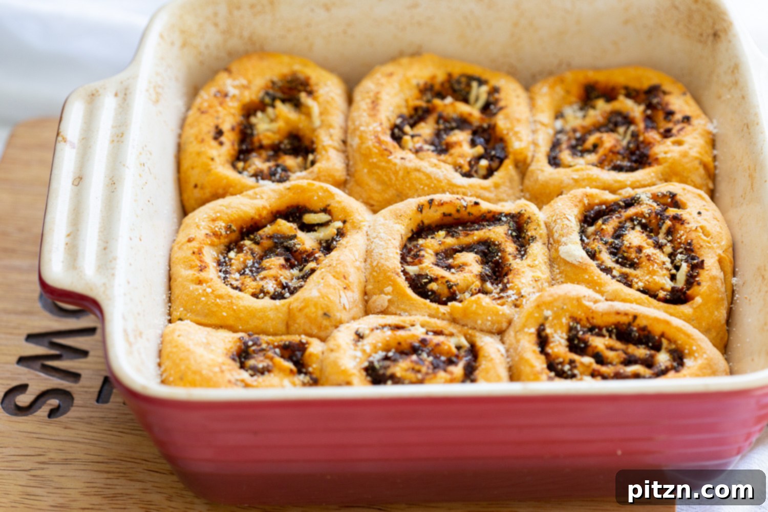 The Ultimate Vegan Pizza Rolls 14 Freshly baked Vegan Pizza Rolls in a ceramic baking dish, golden brown and bubbling, ready to be enjoyed as a savory snack.