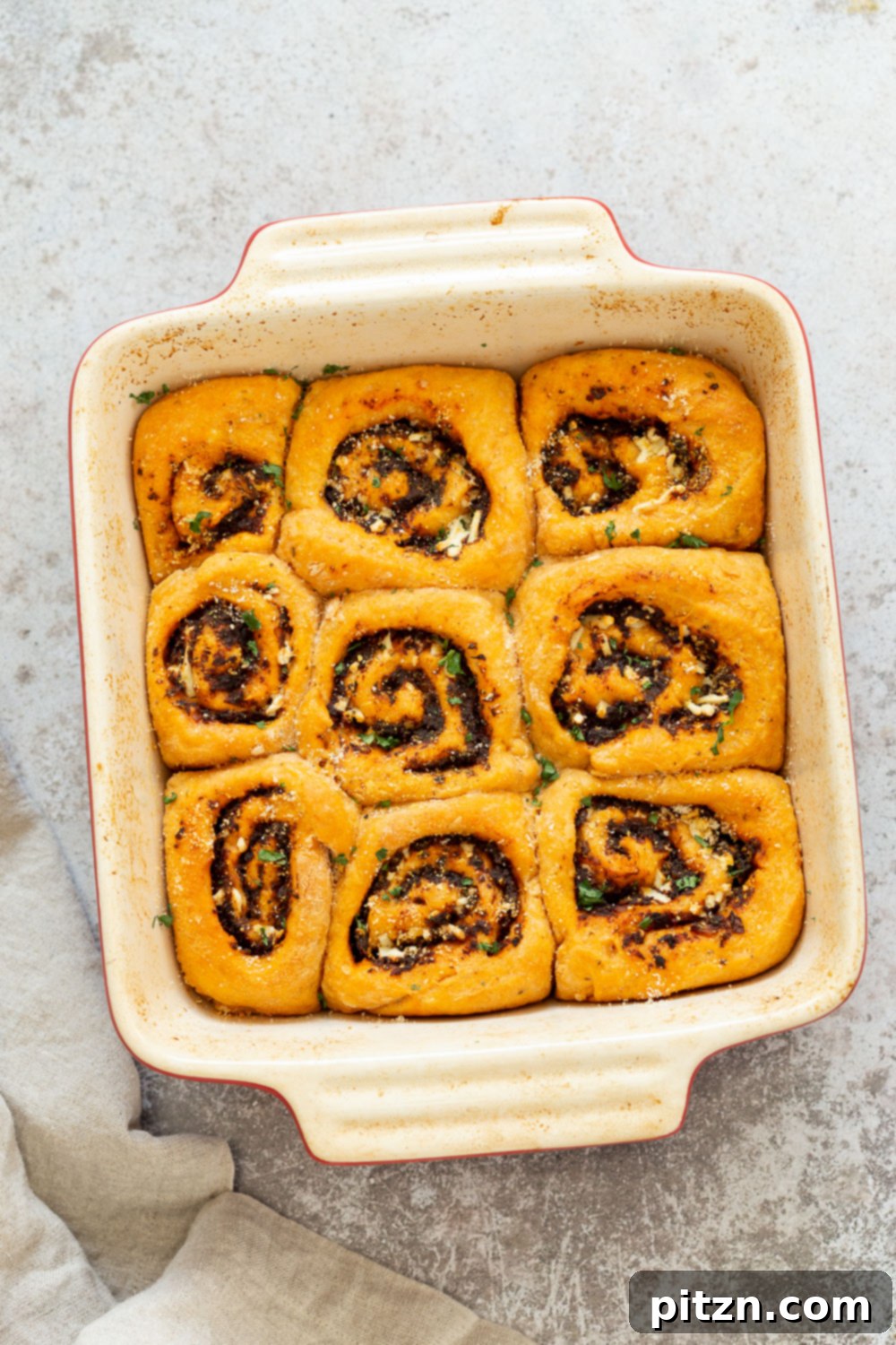 The Ultimate Vegan Pizza Rolls 3 Baked Vegan Pizza Rolls arranged in a ceramic baking dish, ready to be served. Ideal for sharing or enjoying as a flavorful plant-based snack. #Vegan #Soyfree #Nutfree #Recipe #Appetizer
