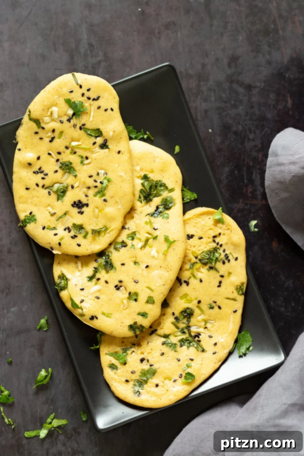 Fluffy Vegan Gluten Free Naan Flatbread on a black serving board, perfectly baked and golden