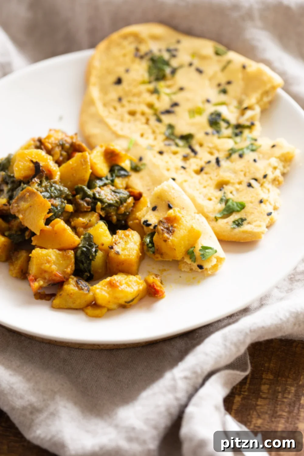 Our delicious Vegan Grain-Free Gluten-Free Naan served on a plate with a vibrant potato spinach stir-fry, showcasing its perfect pairing capabilities