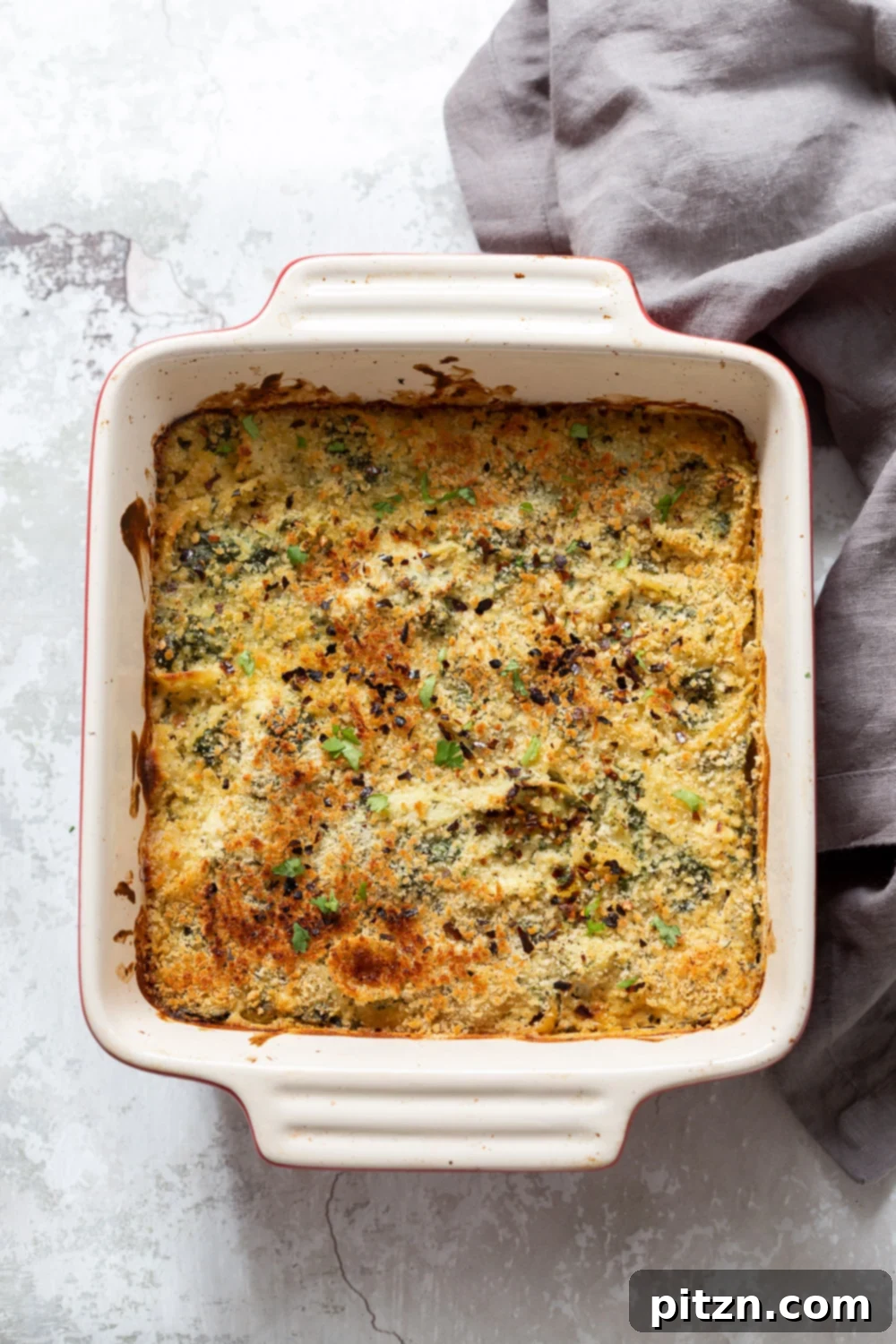 spinach pasta recipe overhead shot of a vegan spinach and artichoke pasta bake with breadcrumb topping