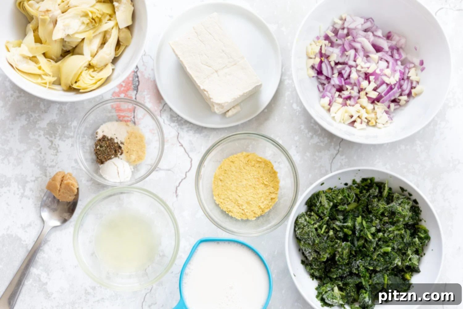 overhead shot of ingredients needed for making spinach artichoke pasta bake 