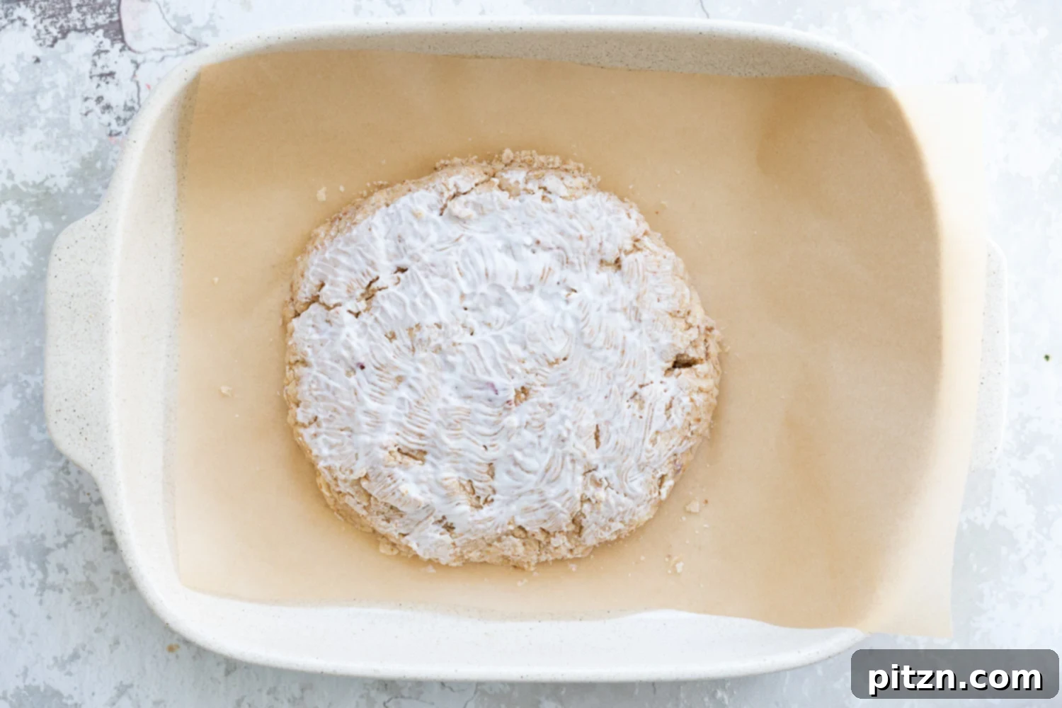 Coconut cream bushed on Dough for our Vegan Churro Scones in a parchment lined baking sheet. 