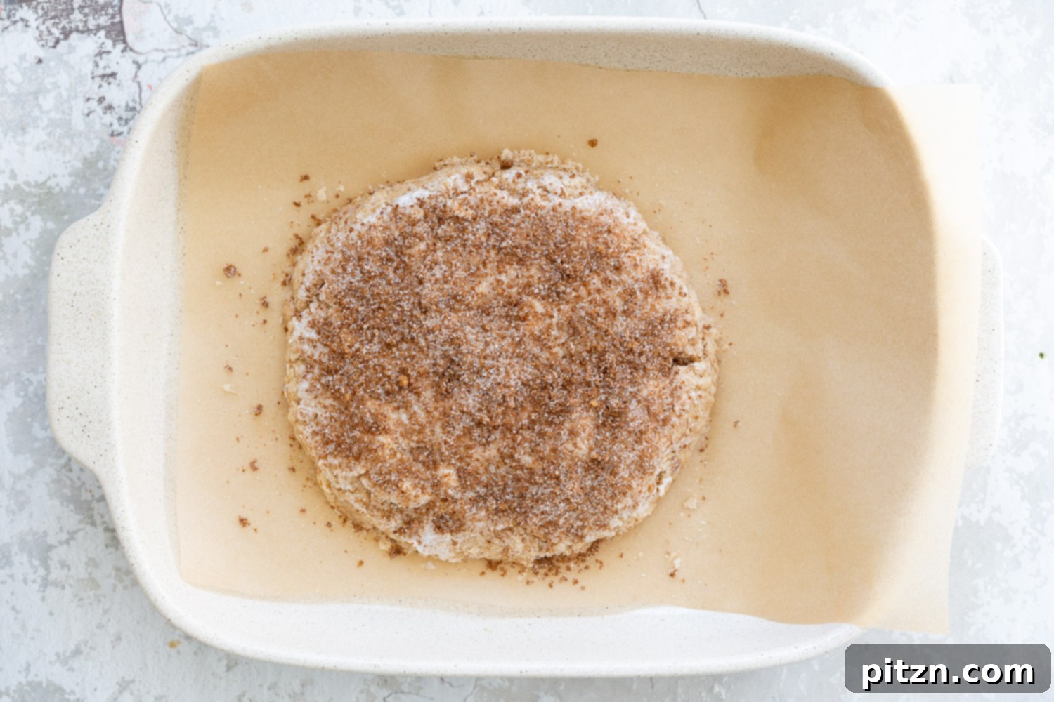 Cinnamon sugar topped Dough for our Vegan Churro Scones in a parchment lined baking sheet. 