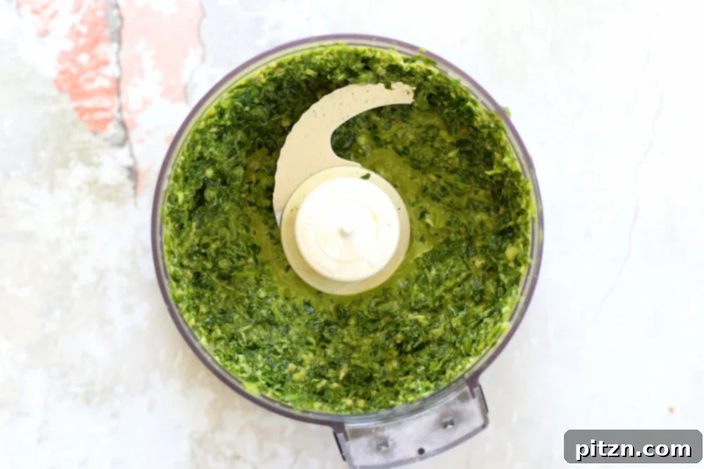 Chimichurri Sauce in a food processor for our Vegan Smashed Potatoes, showcasing fresh herbs.