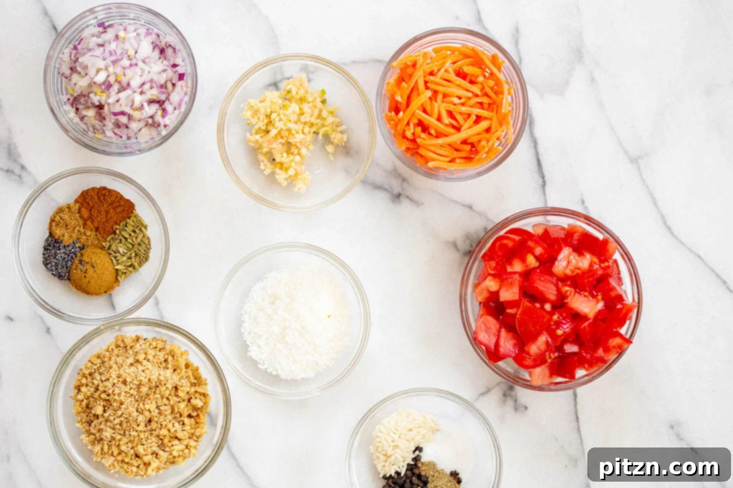 A close-up of various whole spices and raw rice in a bowl, ready to be ground for Vegan Keema Madras.