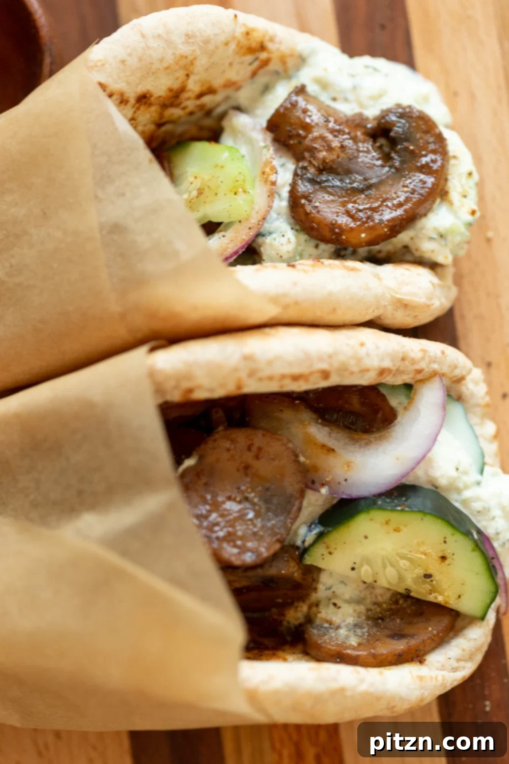 Delicious Vegan Gyros served on a rustic wooden board, showcasing the rich mushroom filling and creamy tzatziki.
