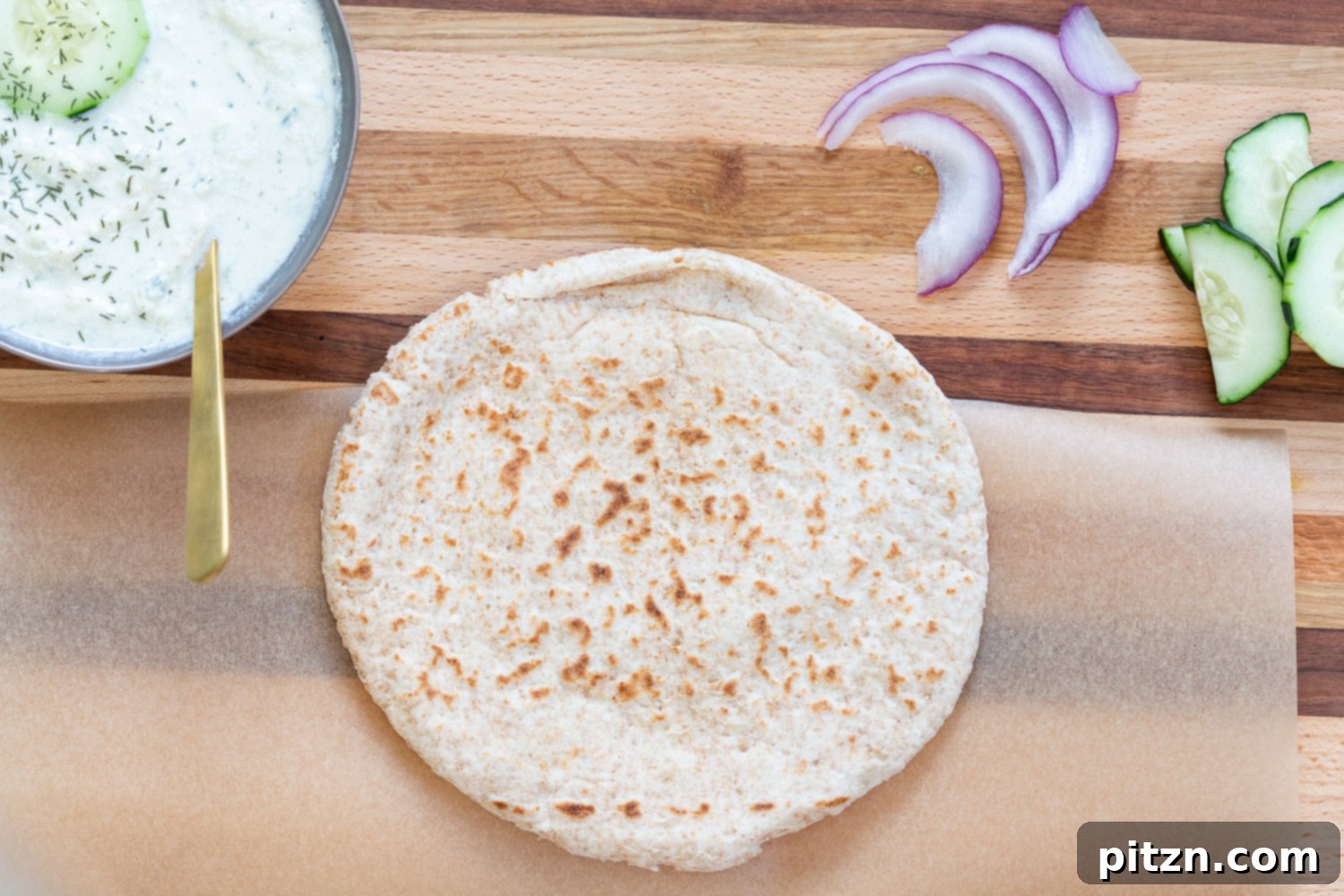 The process of assembling Vegan Gyros with Mushrooms, showing the pita bread and fresh toppings on a wooden board.