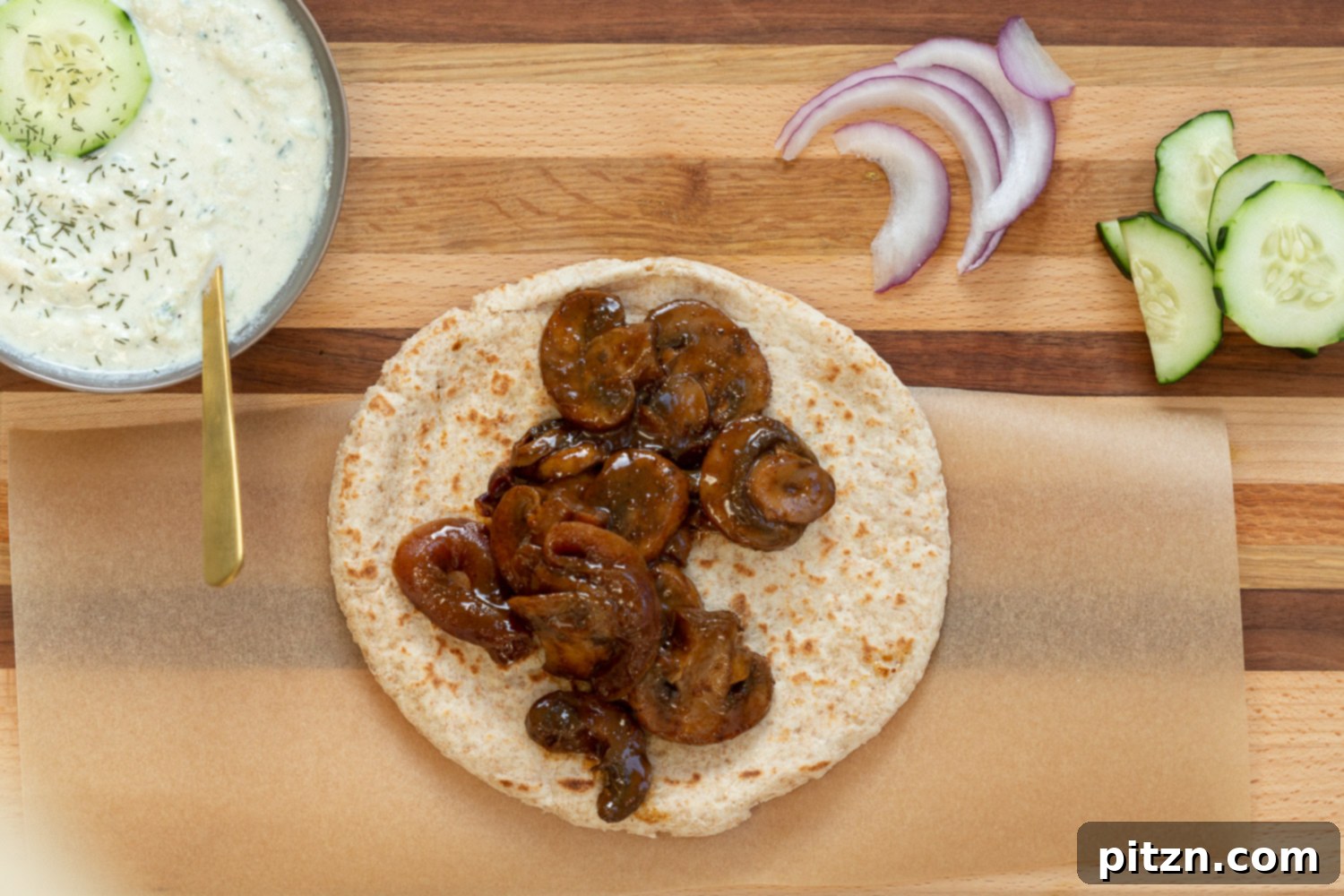The delicious assembly of Vegan Gyros with Mushrooms and creamy tzatziki, perfectly layered on a wooden board.