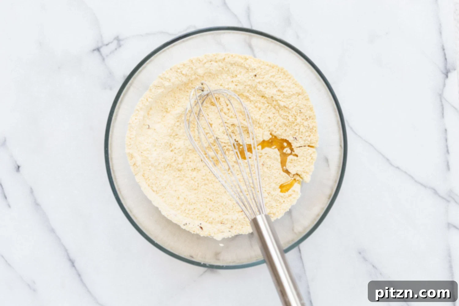 Chickpea flour and oil in a glass bowl for our Vegan Socca