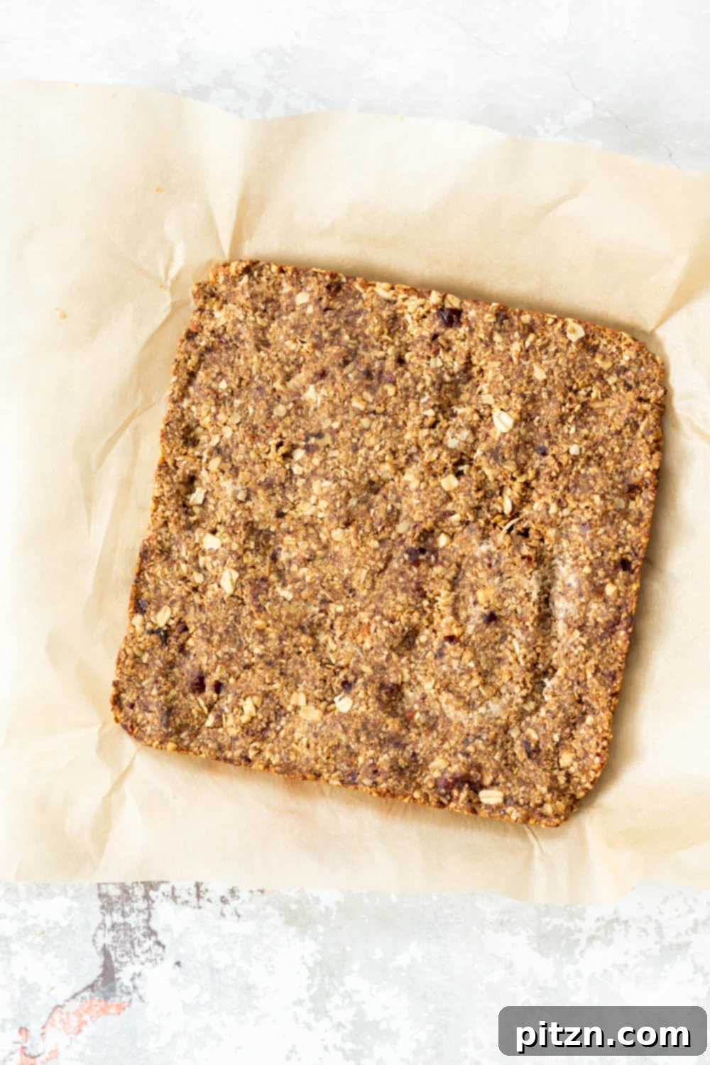 vegan granola bars overhead shot of vegan banana granola bars on a sheet of baking paper ready to be cut