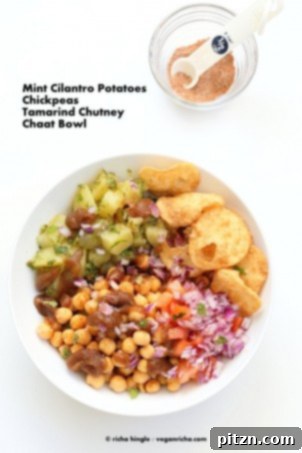 Chickpea Aloo Chaat Bowl. A delicious Indian street food bowl featuring mint cilantro potatoes, spiced chickpeas, and tamarind date chutney, topped with onions, tomatoes, and chaat masala. Vegan, Gluten-free bowl recipe.
