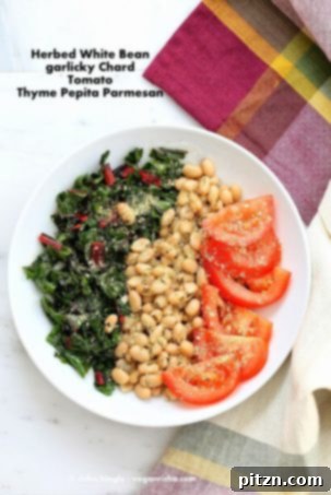26 Vibrant Vegan Bowl Recipes 28 A vibrant and fresh vegan bowl featuring herbed white beans, garlic chard, and a sprinkle of pepita parmesan, offering a delicious and wholesome meal.