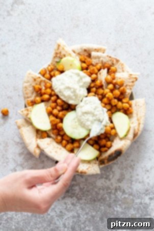 Pita bread, shawarma chickpeas, and creamy tzatziki are artfully arranged, showcasing the layers of our Mediterranean Nachos.