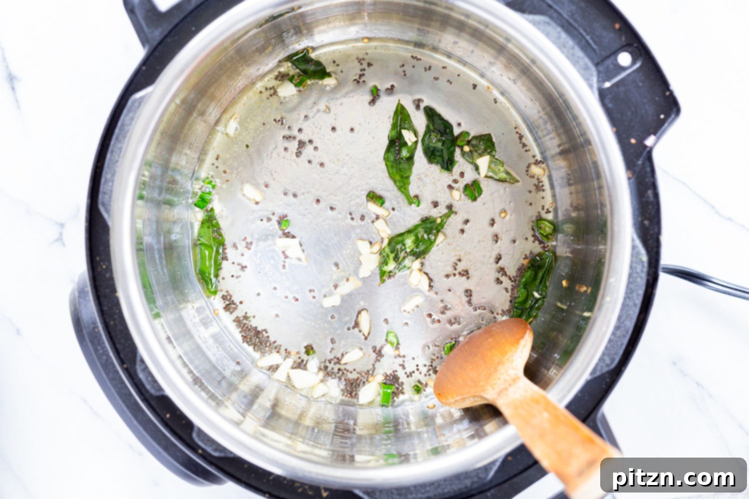 Mustard seeds and curry leaves sizzling in oil in the Instant Pot, forming the aromatic base for Indian Cabbage and Peas.