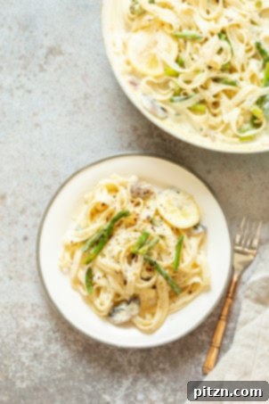 Vegan Lemon Asparagus Pasta - a 30-minute recipe featuring creamy lemon alfredo-style sauce with tofu, fettuccine, and pan-roasted garlic asparagus. Vegan, nut-free, can be gluten-free. #LemonAsparagusPasta #VeganRicha with 17g protein.