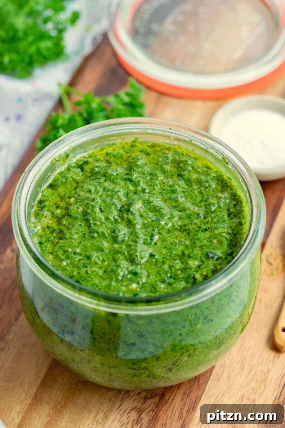Effortless Plant-Based Pesto 9 Cheesy Vegan Pesto in a glass jar kept on wood board, ready for storage
