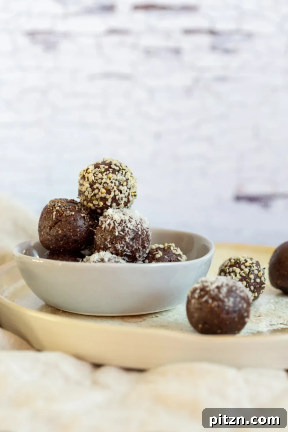 Fudgy Raw Vegan Grain-Free Brownie Bites 3 Close-up shot of Raw Vegan Brownie Bites nestled in a grey ceramic bowl, highlighting their rich texture and inviting appearance.