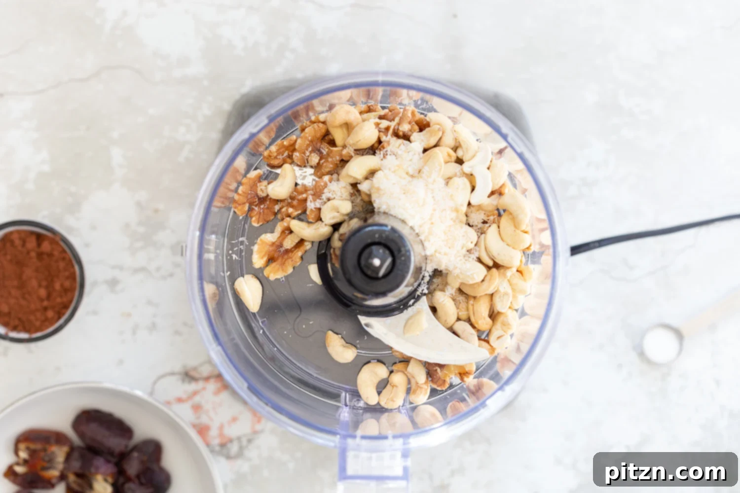 Fudgy Raw Vegan Grain-Free Brownie Bites 5 Cashews, walnuts, and shredded coconut being processed in a food processor, turning into a fine meal for the brownie bites.