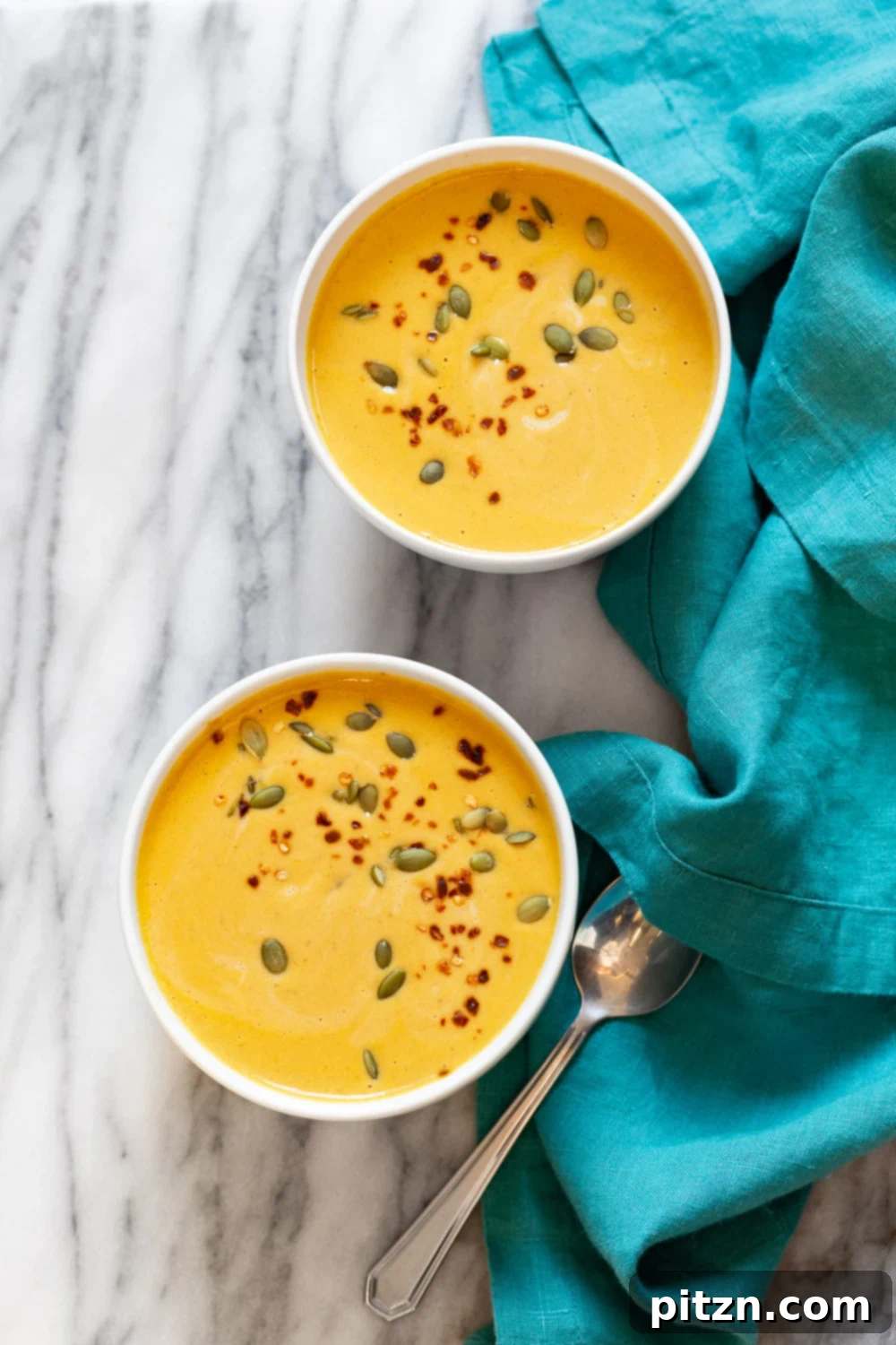 Velvety Vegan Instant Pot Pumpkin Soup 7 Our Creamy Vegan Pumpkin Apple Soup, presented in elegant white bowls and garnished, highlighting its smooth texture and inviting appearance