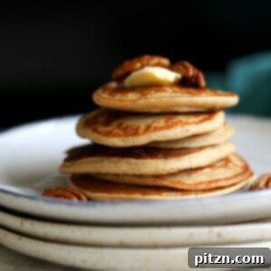 Banana Oat Pancakes Stacked on white plates, ready to eat.