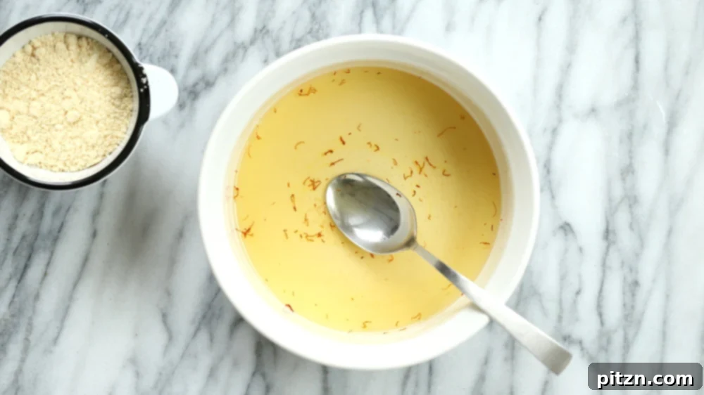 The vibrant sugar and saffron mixture for our Almond Halwa, ready for cooking in a white baking dish.