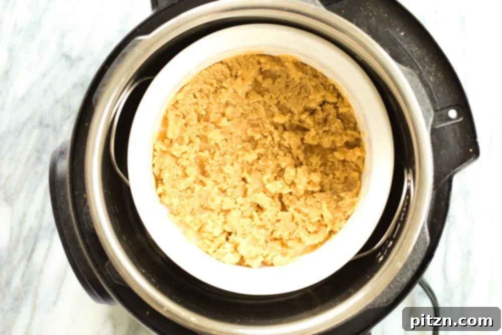 The white baking dish containing the Vegan Almond Halwa mixture, placed inside an Instant Pot for cooking.