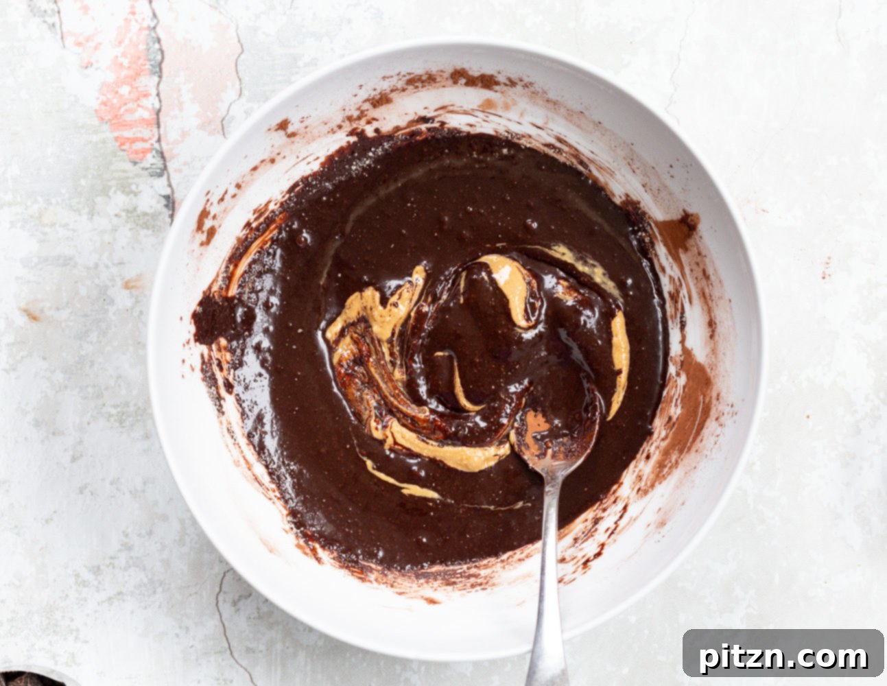 Further mixing of the vegan brownie cookie batter, showcasing its increasing homogeneity and richness