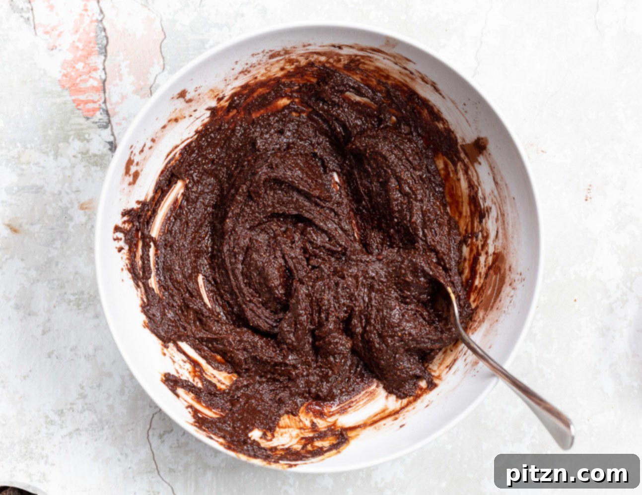The fully mixed vegan brownie cookie batter, smooth and deeply chocolatey, prepared for chilling