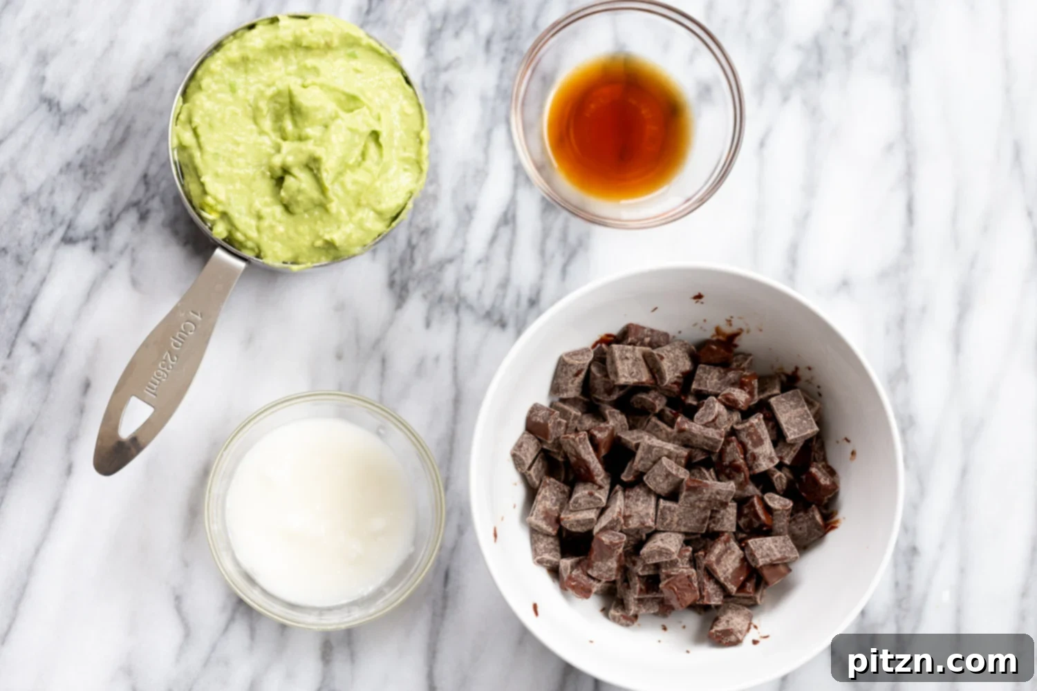 Easy 5-Ingredient Chocolate Avocado Freezer Fudge 4 A colorful array of ingredients for Vegan Chocolate Avocado Freezer Fudge laid out, including chocolate chips, avocado, and spices.