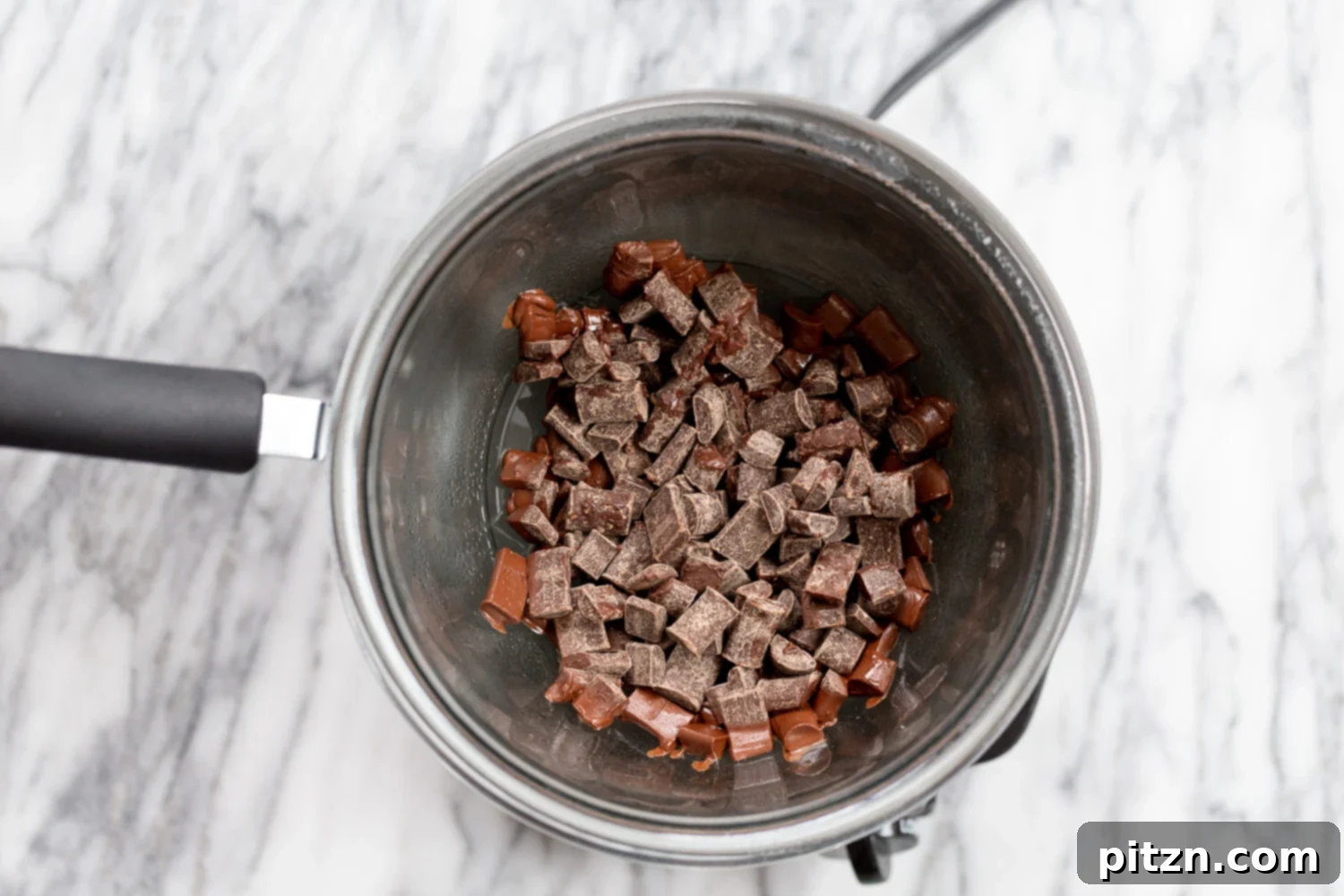 Easy 5-Ingredient Chocolate Avocado Freezer Fudge 5 Vegan chocolate chips melting in a double boiler over simmering water, showing the start of the fudge-making process.