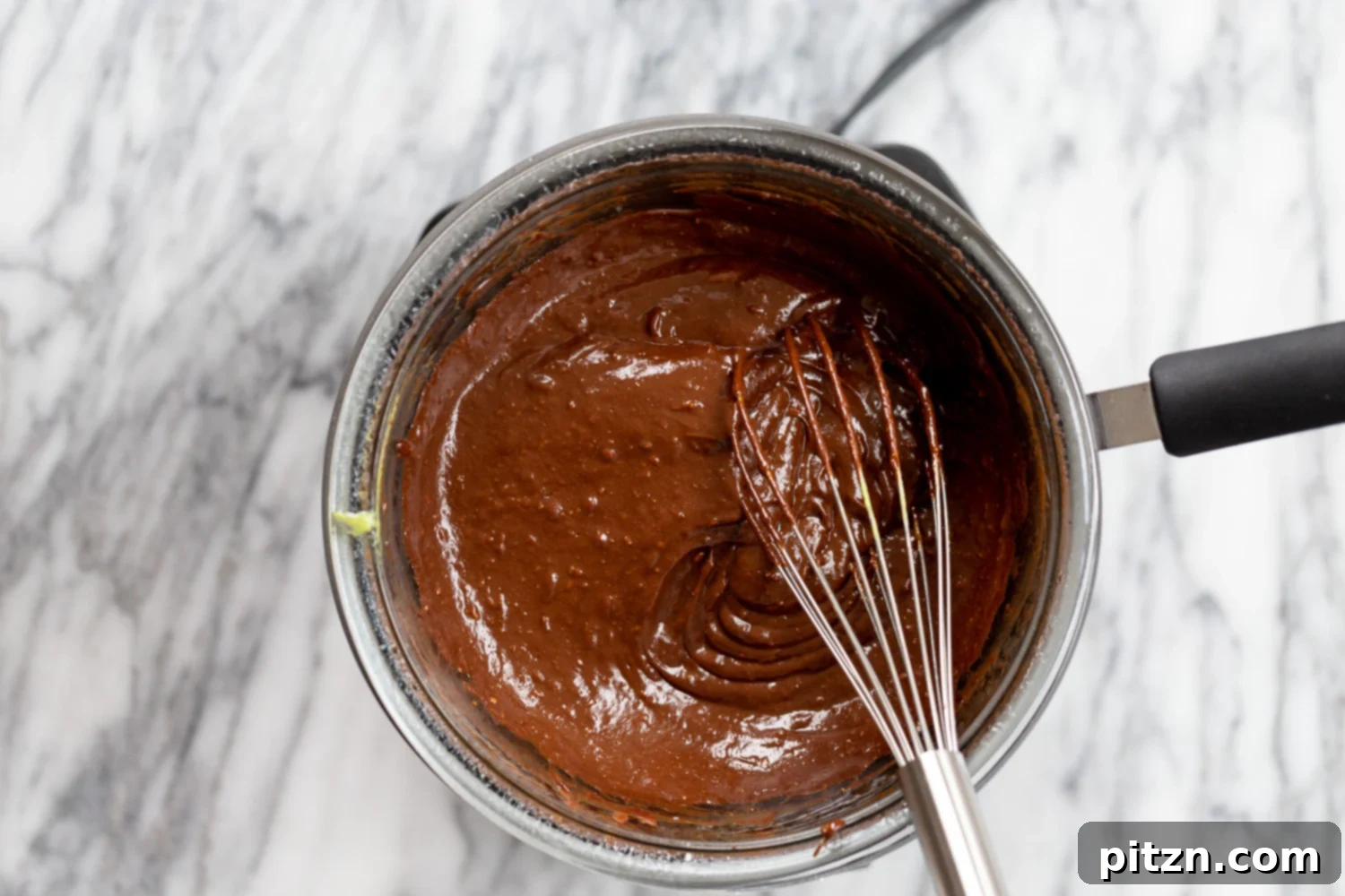 Easy 5-Ingredient Chocolate Avocado Freezer Fudge 7 Mashed avocado being gently folded into the melted chocolate mixture, creating a rich and creamy base.