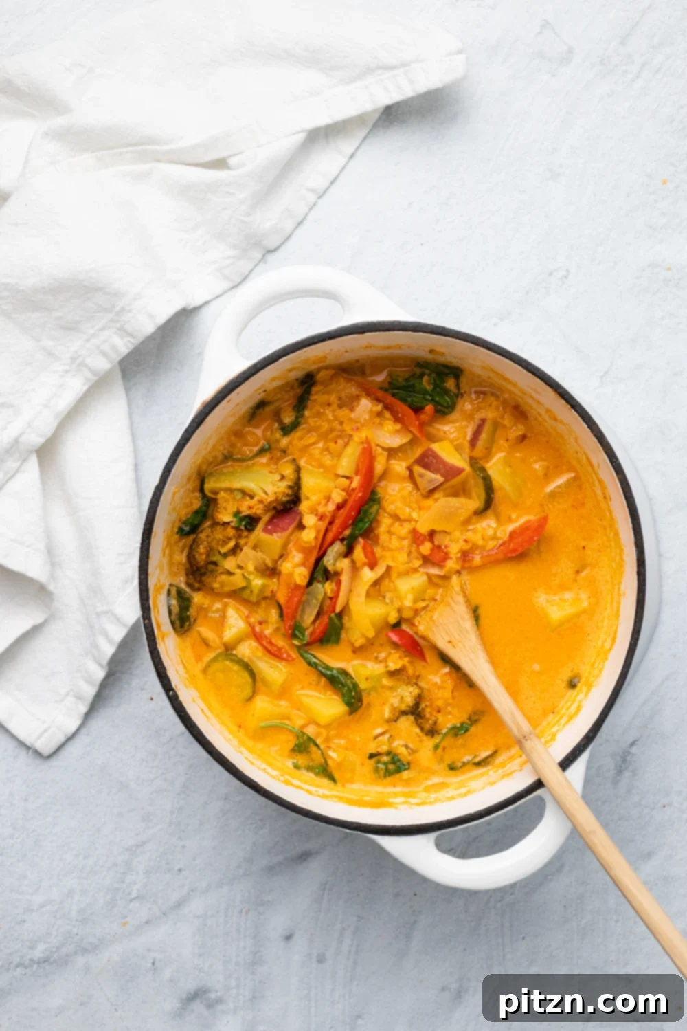 sweet potato curry overhead shot of a white ceramic pot filled with vegan red lentil sweet potato curry