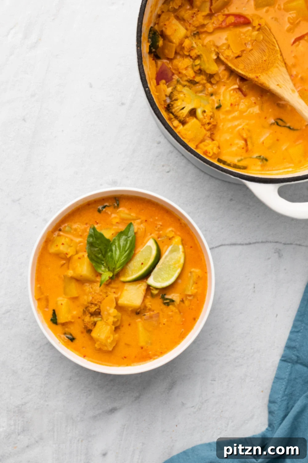 sweet potato curry a bowl of vegan Thai sweet potato curry with red lentils next to a pot