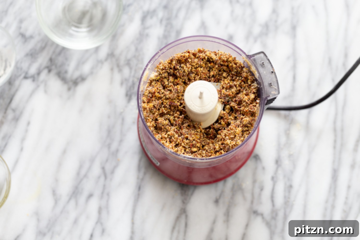 The perfectly moistened crumb mixture for vegan pizza bites, scooped into a bowl, demonstrating the ideal consistency before chilling and forming. This image highlights the texture that holds together when pressed, ready for the next step in preparing healthy, grain-free snacks.
