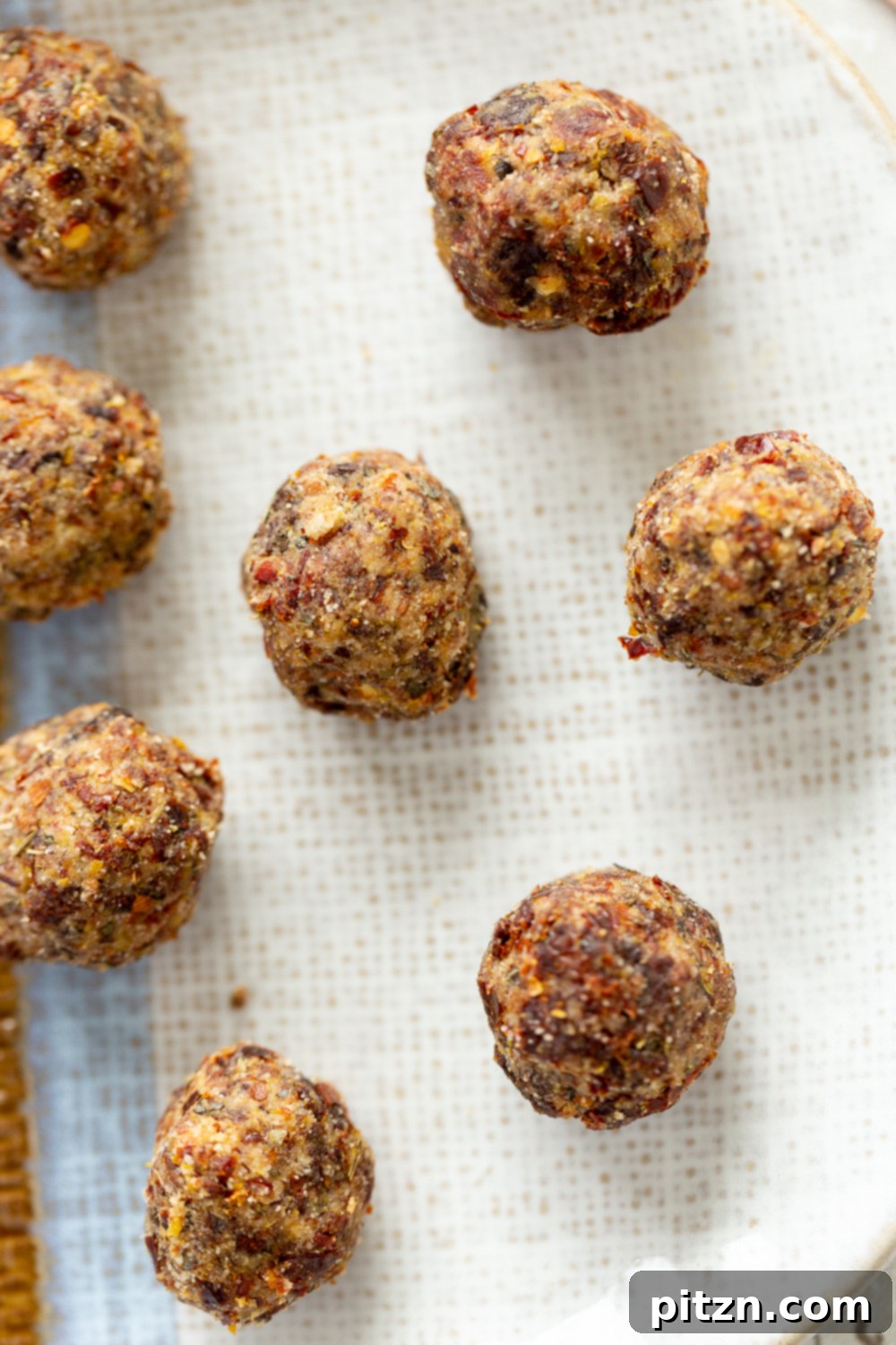 An overhead shot showcasing a batch of freshly baked gluten-free vegan pizza snack bites cooling on a parchment-lined baking sheet, emphasizing their wholesome and appetizing appeal.